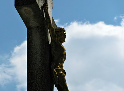 foto van een jesus beeld aan een krijs met blauw lucht in de achtergrond
