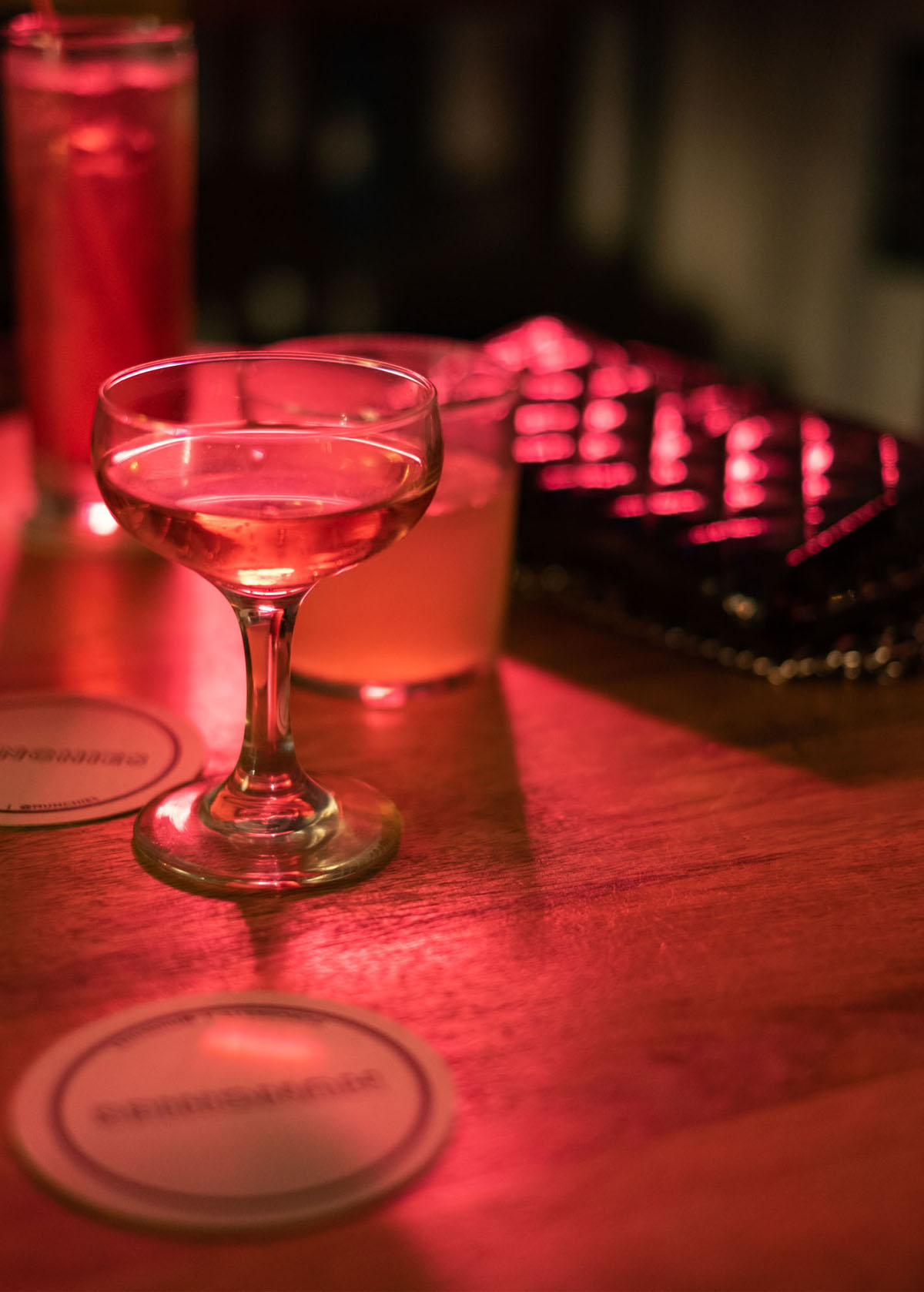 een glas met alcohol op tafel in een donkere ruimte